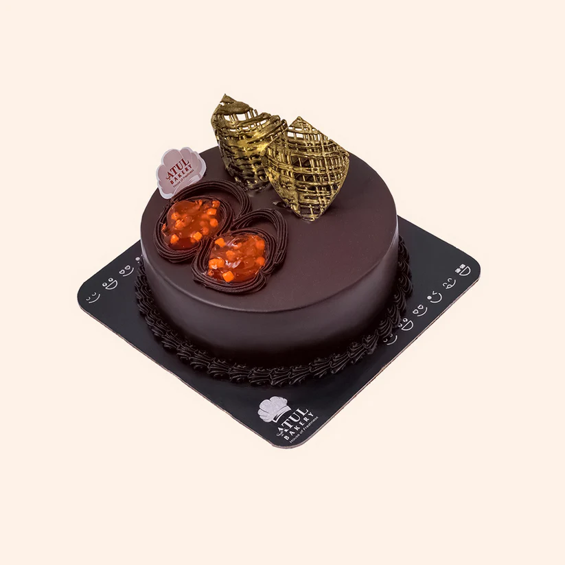Cake Decoration Process – A baker's hand skillfully piping cream onto a layered cake, showcasing the artistry behind Atul Bakery’s signature creations.