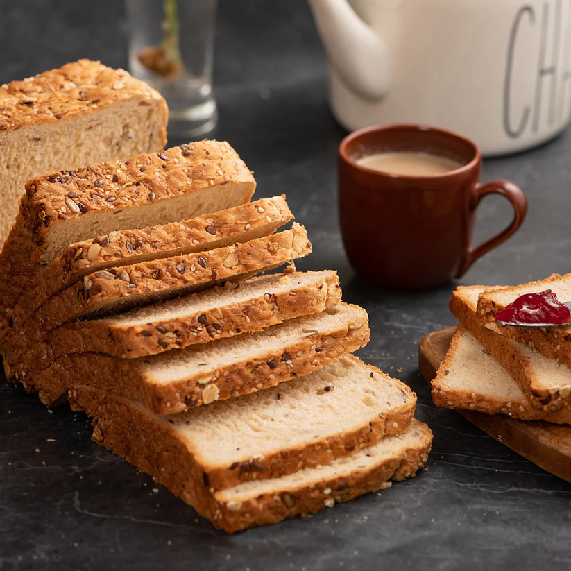 Freshly Sliced Multi-Grain Bread on a Wooden Board – Close-up shot of a loaf with visible seeds and grains, emphasizing its nutritious, rustic appeal.